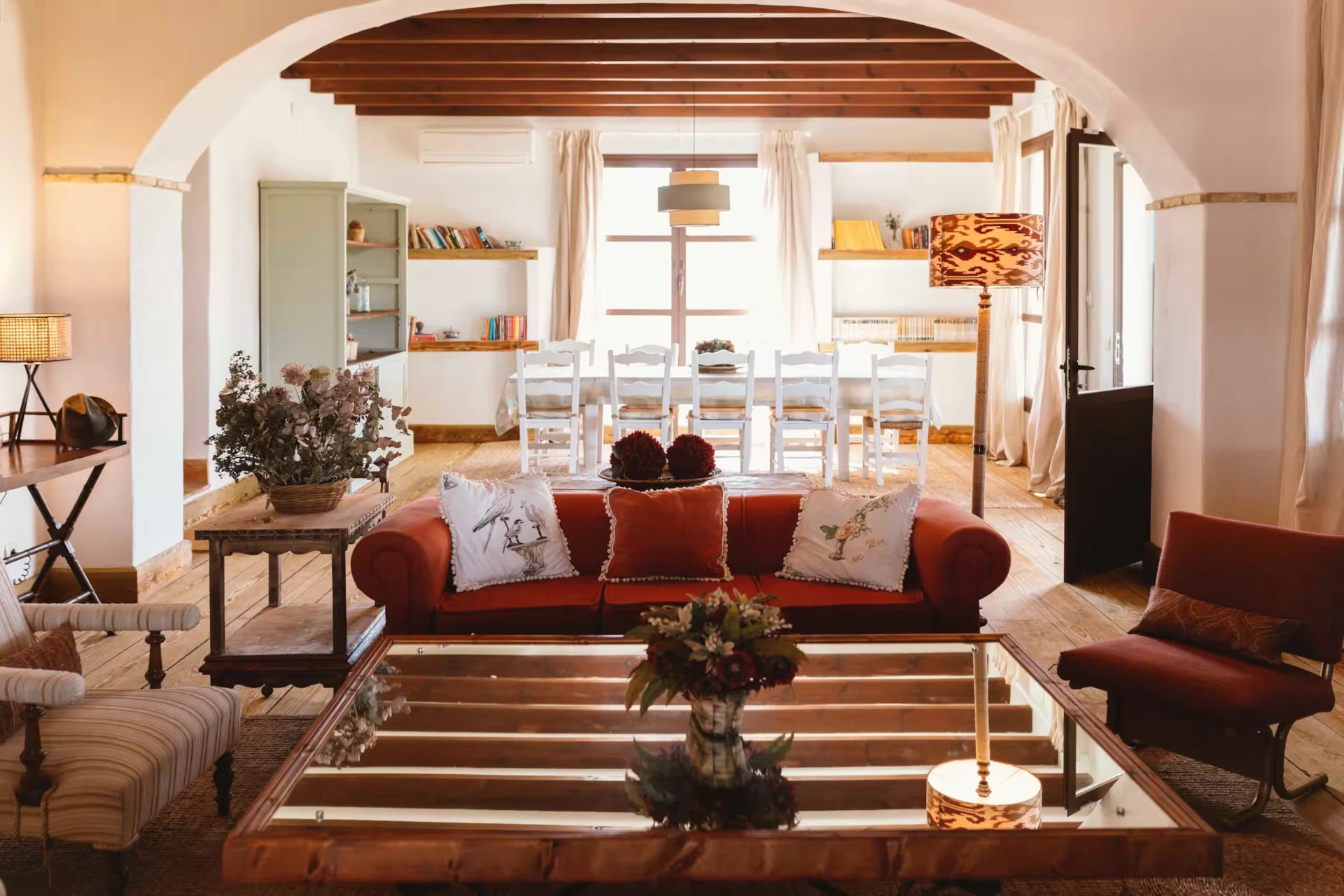 Warm living room with terracotta sofa and long dining table inside the estate